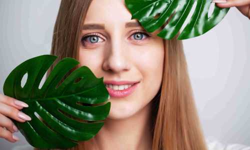 face-care-young-woman-holding-a-green-leaf